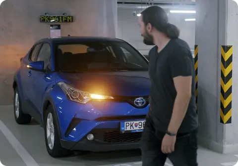 Driver arriving at a free space in a car park with live occupancy signage